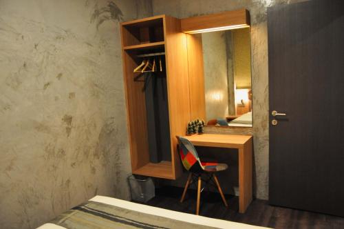 a bedroom with a desk with a mirror and a chair at Valya Hotel, Ipoh in Ipoh