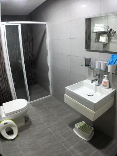 a bathroom with a toilet and a sink and a shower at 23 Here B&B in Hualien City