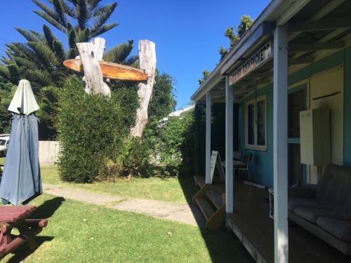 a house with a surfboard on the side of it at Apollo Bay Backpackers in Apollo Bay