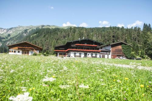 a couple of buildings in a field of flowers at Appartements Schrambacherhof in Achenkirch