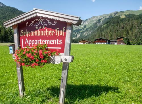 a sign in the middle of a field with flowers at Appartements Schrambacherhof in Achenkirch