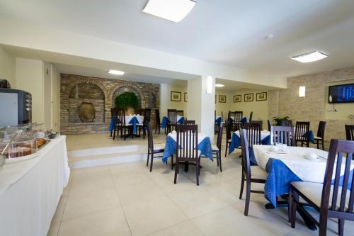 a dining room with tables and chairs with blue tablesearcher at Hotel Donnini in Assisi