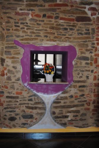 a window in a brick wall with a vase of flowers at All'Ombra del Castello in Cigliè