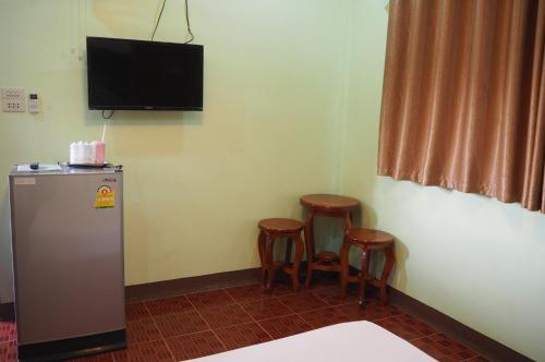 Zimmer mit zwei Hockern und einem TV an der Wand in der Unterkunft 555 Resort in Udon Thani
