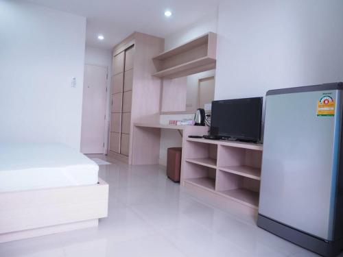a white kitchen with a refrigerator in a room at Baan mek mok in Bangkok