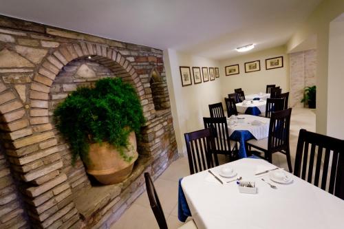 a dining room with tables and a brick wall at Hotel Donnini in Assisi