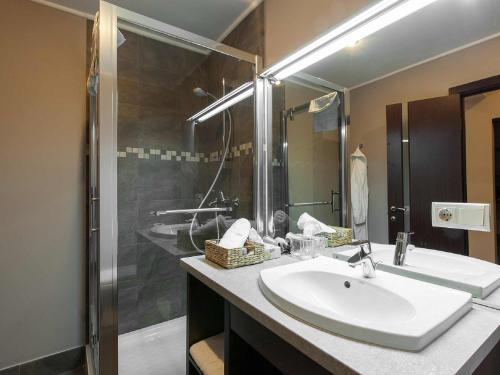 a bathroom with a white sink and a shower at Bontiak Hotel in Kyiv
