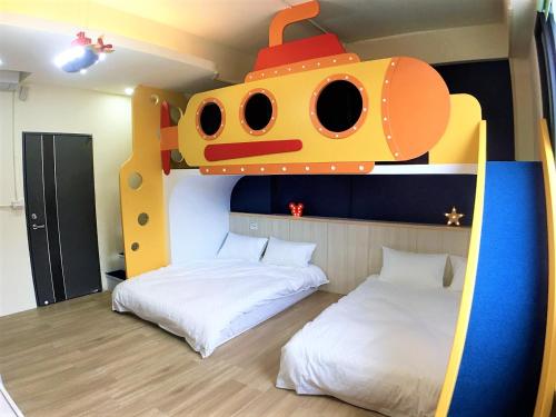 a room with two beds and a train bunk bed at 23 Here B&B in Hualien City