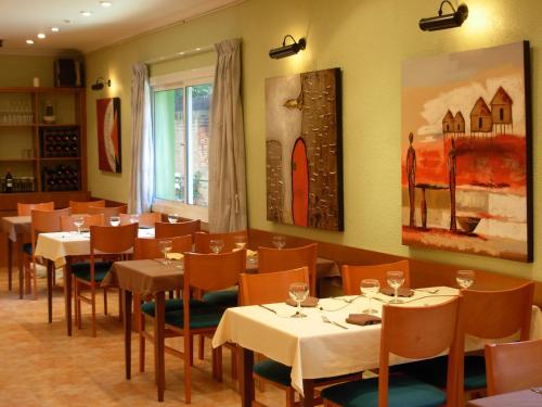 un restaurante con mesas y sillas y una pintura en la pared en Hotel Rodsan Suizo, en Castelldefels