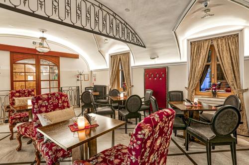 a restaurant with red chairs and tables and windows at Arbia Dorka Heritage Palace in Varaždin