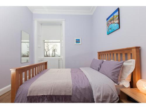 エディンバラにあるPass the Keys Spacious 2-BR Flat for 4 in Morningsideのベッドルーム(紫色の掛け布団付きのベッド1台付)