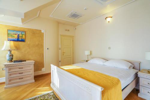 a bedroom with a large white bed and a dresser at Arbia Dorka Heritage Palace in Varaždin