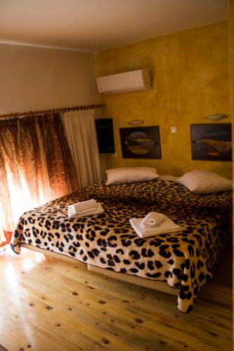 a bedroom with a leopard print bed with towels on it at Bonne Nuit Pension in Nafplio