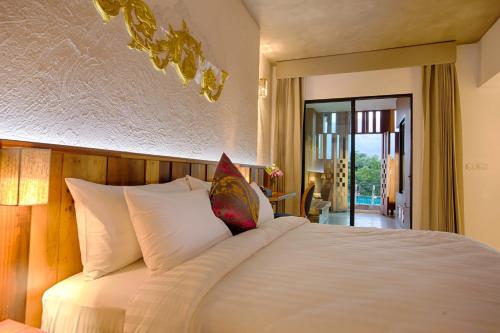 Ένα ή περισσότερα κρεβάτια σε δωμάτιο στο Natee The Riverfront Hotel Kanchanaburi