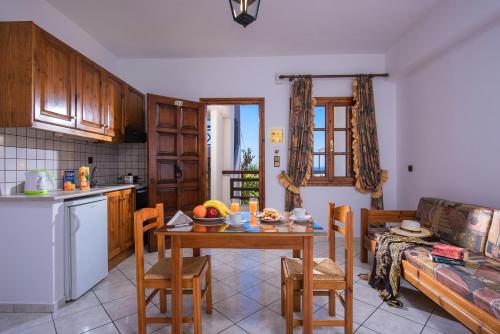 a kitchen and living room with a table and chairs at Rena Apartments in Gouves