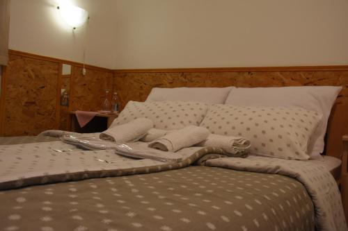 a bed with a pair of slippers on top of it at Hotel Duga in Novi Sad
