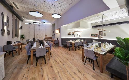un restaurante con suelo de madera, mesas y sillas en TWO TIMEZ - Boutique Hotel - with AC en Zell am See