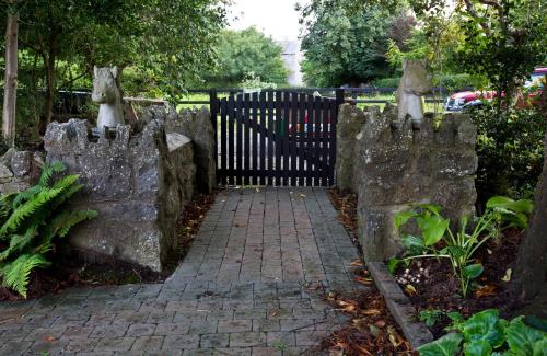 a stone fence with a brick walkway next to a gate at Gleneven Guest House in Inniskeen