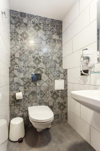 a bathroom with a toilet and a sink at Old Town Trio Apartments in Vilnius
