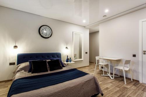 a bedroom with a bed and a clock on the wall at Old Town Trio Apartments in Vilnius