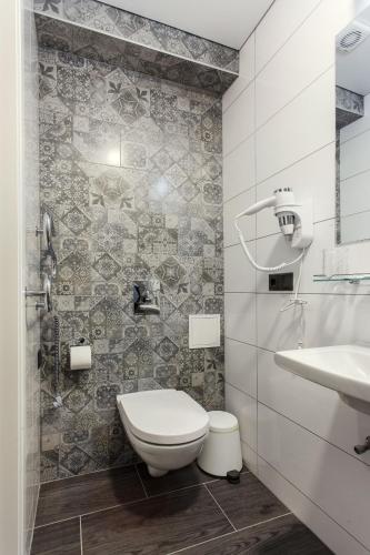 a bathroom with a toilet and a sink at Old Town Trio Apartments in Vilnius