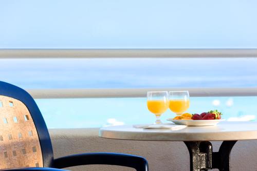 Ein Tisch mit zwei Gläsern Orangensaft und einem Teller Obst in der Unterkunft Hipotels Mercedes Aparthotel in Cala Millor