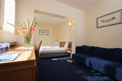 a hotel room with a couch and a bed at Hotel Tomislavov Dom in Zagreb