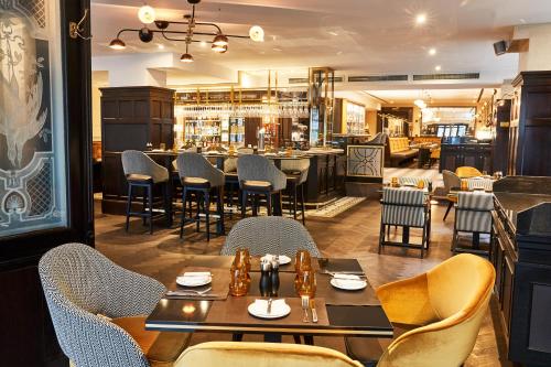 a restaurant with tables and chairs and a bar at Steigenberger Icon Frankfurter Hof in Frankfurt/Main