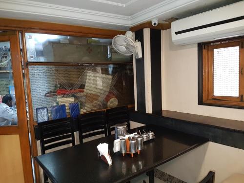 a kitchen with a black counter and a window at Hotel Sorrento Guest house Anna Nagar East Metro Shenoy Nagar metro budget monthly daily rooms in Chennai