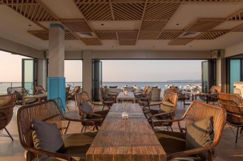 a restaurant with a long table and chairs at Cape Sienna Phuket Gourmet Hotel & Villas - SHA Extra Plus in Kamala Beach