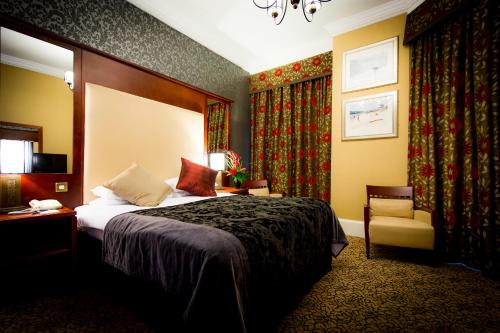 a hotel room with a bed and a chair at Best Western Queens Hotel in Dundee