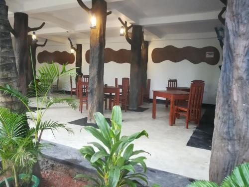 a room with a table and chairs and trees at The Nature Park Villa in Sigiriya