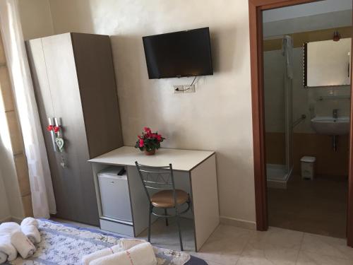 Habitación con escritorio, lavabo y TV. en B&B Cuore di Gallipoli, en Gallipoli
