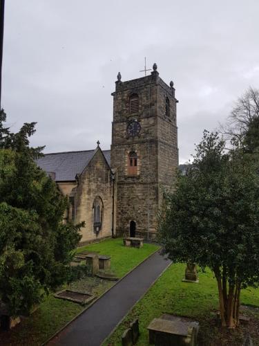 an old church with a clock tower with a road at The Hand Hotel Llangollen by Compass Hospitality in Llangollen