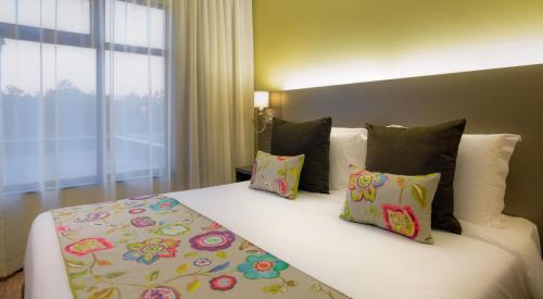a bedroom with a bed with pillows and a window at Tamarind Tree Hotel in Nairobi