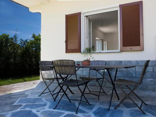une table et des chaises assises sur une terrasse dans l'établissement Vitali Apartment JR, à Bellagio