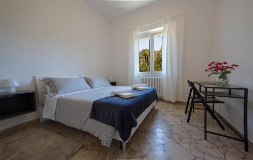 een slaapkamer met een bed, een tafel en een raam bij Vitali Apartment JR in Bellagio