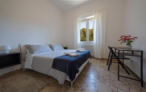 a bedroom with a bed and a table and a window at Vitali Apartment JR in Bellagio