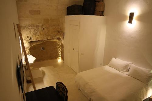 a bedroom with a bed in a room with a stone wall at Albergo Diffuso Il Casale in Ginosa