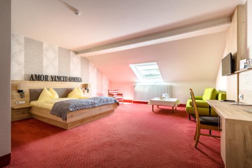 ein Schlafzimmer mit einem Bett und einem Schreibtisch in einem Zimmer in der Unterkunft Riverresort Donauschlinge in Haibach ob der Donau