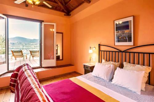 a bedroom with a large bed and a balcony at Villa Kalypso and Villa Kirki in Skopelos Town