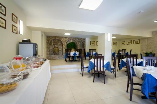 uma sala de jantar com mesas e cadeiras num restaurante em Hotel Donnini em Assis