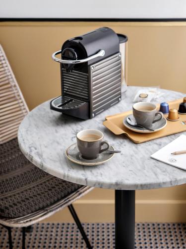 a table with two cups of coffee on it at Doisy Etoile - Orso Hotels in Paris