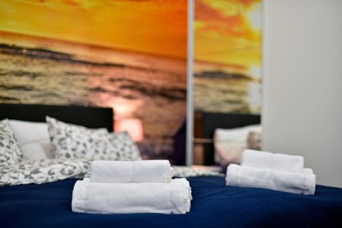 uma cama com toalhas com um cobertor azul em Apartment Frenki- Tkalčićeva -self check in- em Zagreb
