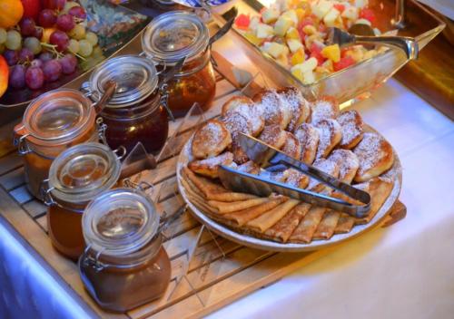 a table with a plate of pastries and jars of honey at Swiss Hotel in Lviv