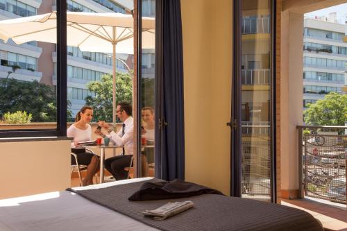 a hotel room with people sitting at a table on a balcony at Best Western Blu Hotel Roma in Rome