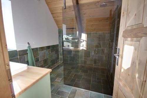 a bathroom with a shower with green tiles at Chalupa U smrku in Horní Maršov