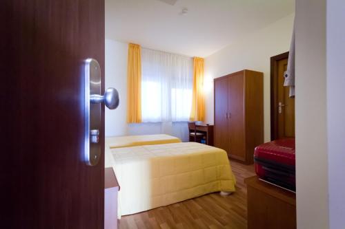 a hotel room with two beds and a window at Hotel Donnini in Assisi