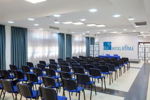a conference room with blue chairs and a screen at Best Western Blu Hotel Roma in Rome