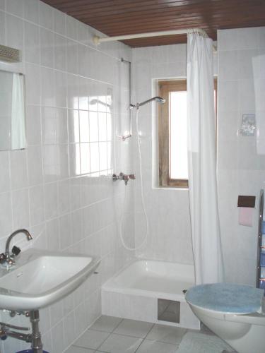 a white bathroom with a tub and a sink at Haus Mondspitze in Bürserberg